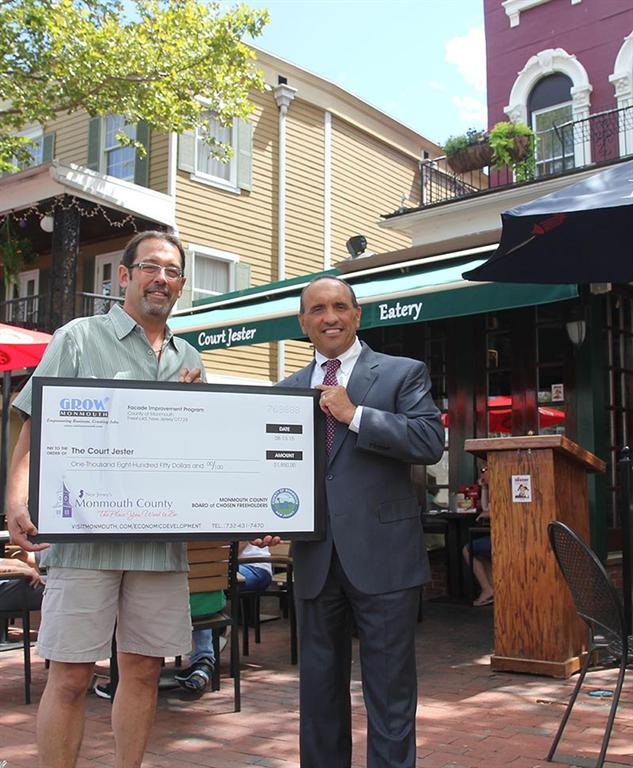 Court Jester of Freehold co-owner Anthony Ciafardini accepts a $1,850 Monmouth County Façade Improvement Program check from Freeholder Thomas A. Arnone on Aug. 13 in Freehold, NJ.